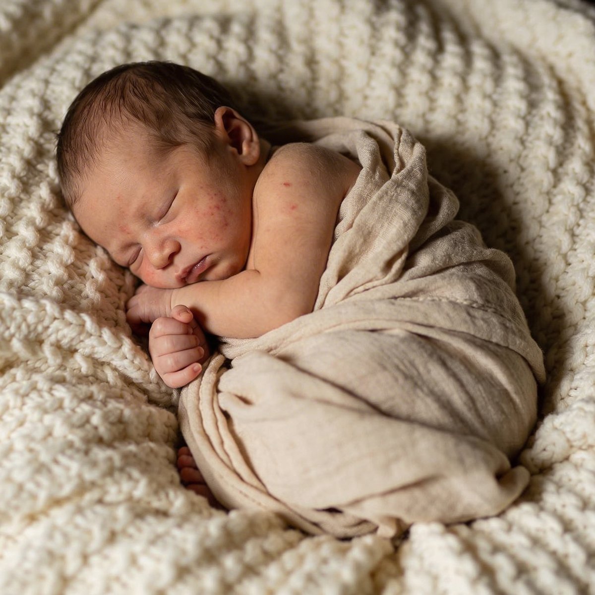 Nyfödd bebis sovandes i en konstnärlig hopkrullad pose, fotograferad mellan 5 och 15 dagar