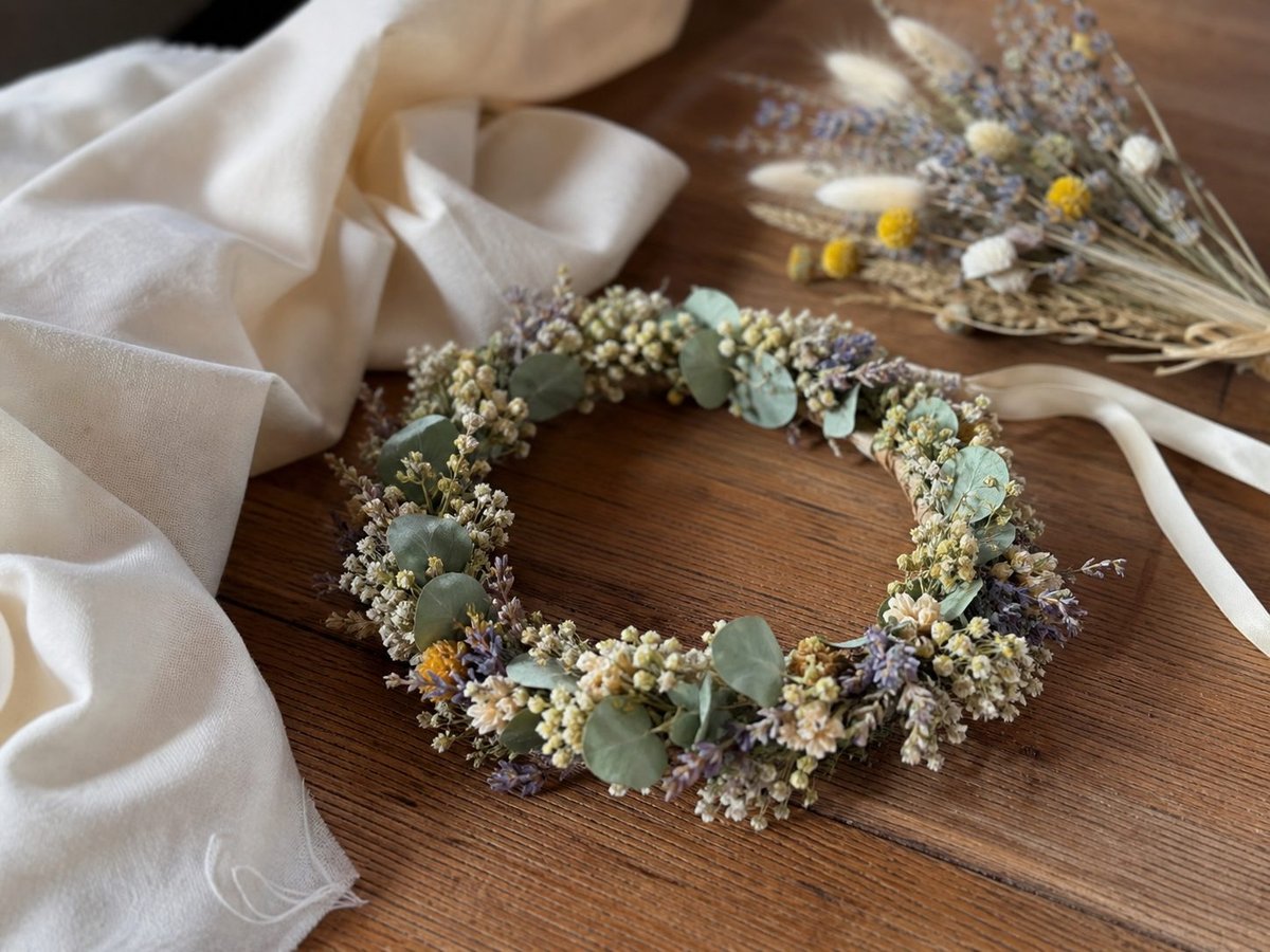 Gravid kvinna i lång beige flytande klänning under gravidfotografering i naturligt ljus, magen väl framhävd